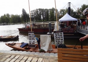 Tradycyjna Wiślana łódź płaskodenna ozdobiona zdjęciami z budowy stoi przy bulwarze na festiwalu Loary w Orleanie