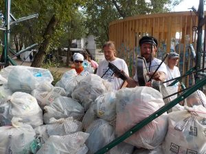 Wolontariusze zdejmują worki ze śmieciami z przyczepy